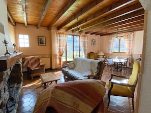 A cozy room with a fireplace, a sofa, a dining table, and chairs. - L'Olivier - QUILLAN - Gîte (QUILLAN)