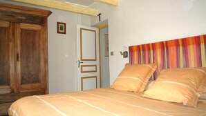 Une chambre à coucher avec un lit, une armoire en bois et une porte.