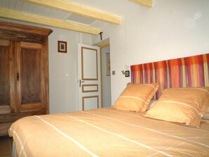 Ein Schlafzimmer mit einem Bett, einem Holzschrank und einer Tür.