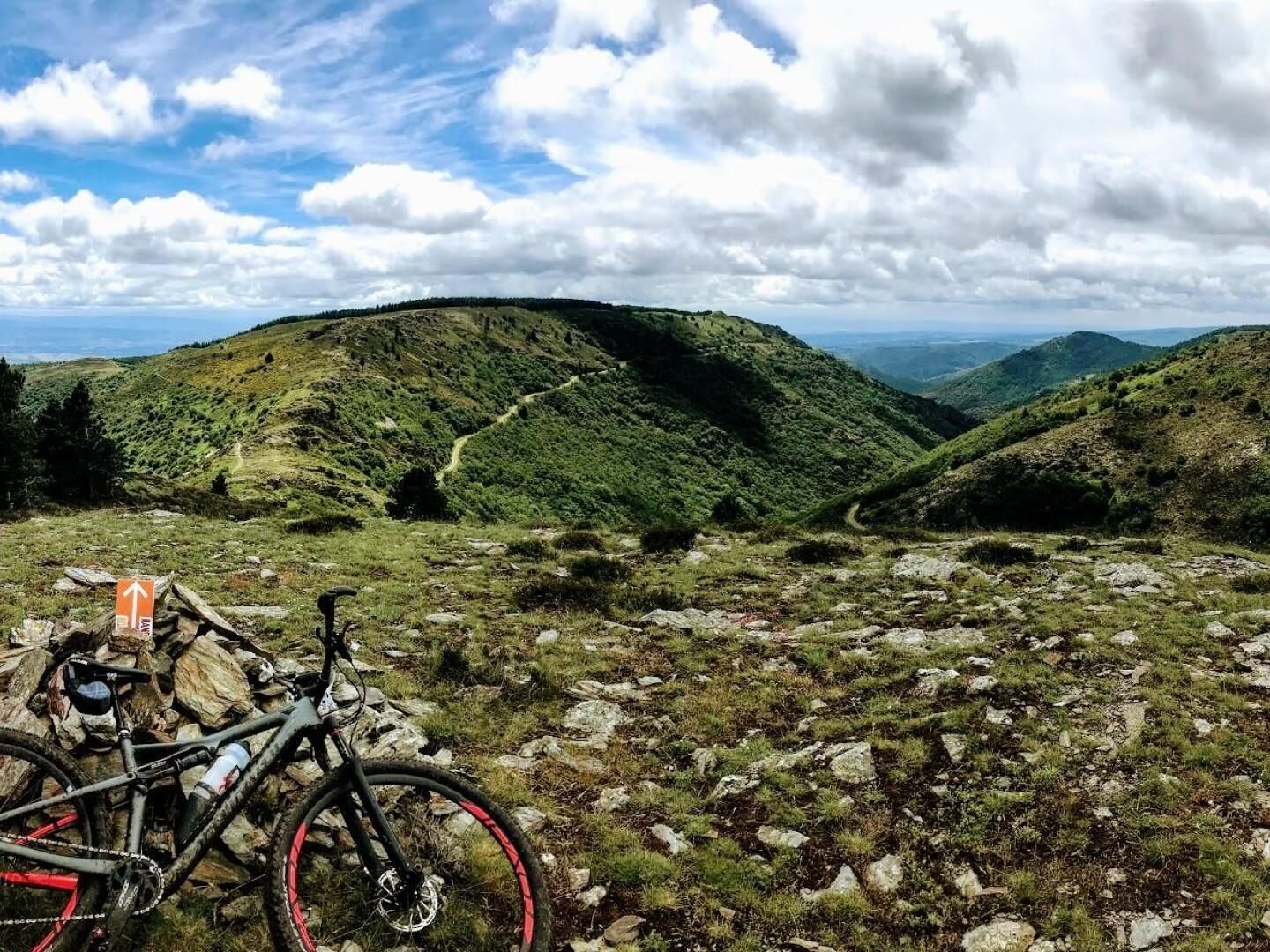 Paisagem montanhosa com uma bicicleta estacionada em terreno rochoso.