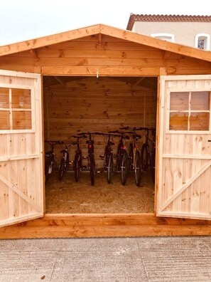 Een houten constructie met een open deur, waar fietsen in staan.