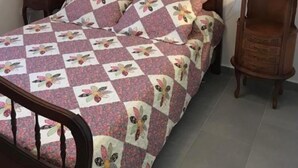 A bed with a floral quilt, two bedside tables with lamps, and a painting on the wall. - Les Oliviers - CARCASSONNE (CARCASSONNE)