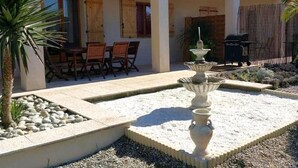 A patio with a fountain, outdoor seating, and a pool. - Les Oliviers - CARCASSONNE (CARCASSONNE)