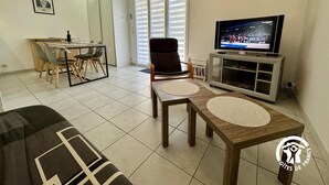 En stue med tv, spiseplads og sofa.