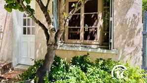 Una casa con una finestra, un albero e una porta.
