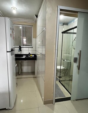 Una cocina compacta con refrigerador, pileta y ventana.