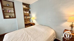 Una camera da letto con un letto, una libreria e una parete in pietra.