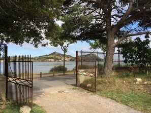 Ein verschlossenes Parktor mit einem befestigten Weg, der zu einem Gewässer führt.