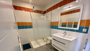 A bathroom with a shower, a sink, and a toilet. - L'ancienne Cave - ROQUEFORT DES CORBIERES (ROQUEFORT DES CORBIERES)