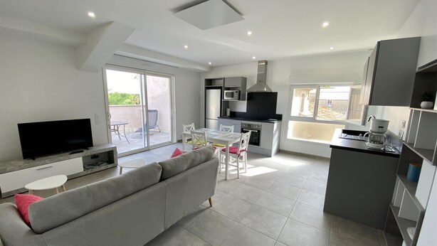 A modern apartment with a living room, dining area, kitchenette, and a balcony. - L'ancienne Cave - ROQUEFORT DES CORBIERES (ROQUEFORT DES CORBIERES)