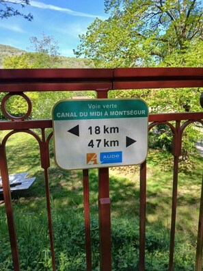 A directional sign for a canal route, indicating distances to Montségur and another destination. - Les Coquelicots - SONNAC SUR L'HERS (SONNAC SUR L'HERS)