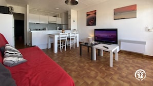 Un appartement moderne comprenant un espace de vie, une cuisine et un coin repas.