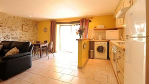 A compact living space with a sofa, dining table, and a small kitchen area including a washing machine and a refrigerator. - Alice - MONTGAILLARD (MONTGAILLARD)