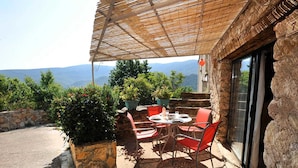 An outdoor patio with a table and chairs, surrounded by potted plants and a view of the mountains. - Alice - MONTGAILLARD (MONTGAILLARD)