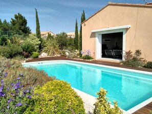 A swimming pool surrounded by lush greenery and a building with a patio. - Vista Alegre - FITOU (FITOU)