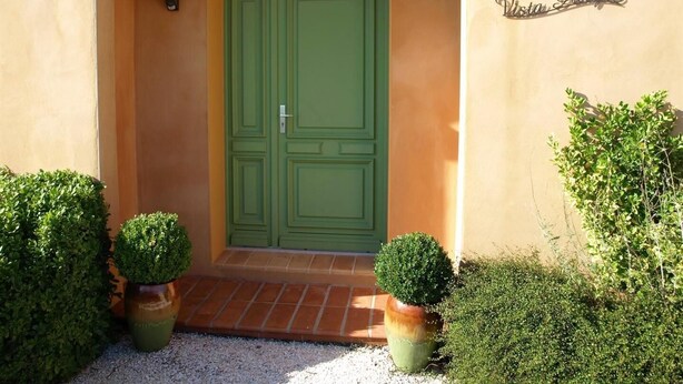 Une entrée d’immeuble avec une porte double verte, un petit porche et une enseigne indiquant « Vista Alegre ».