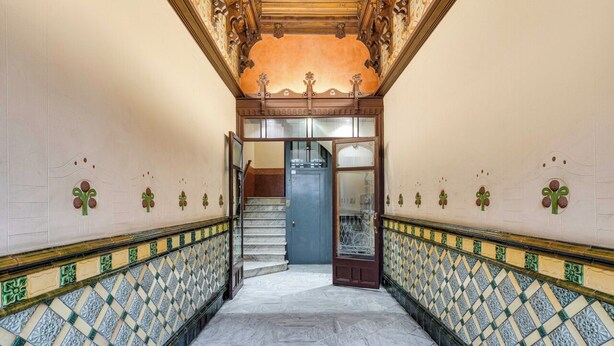 A hallway with patterned floor tiles, a staircase, and a door leading to another room. - Gran Via City Center Apartment (Barcelona)