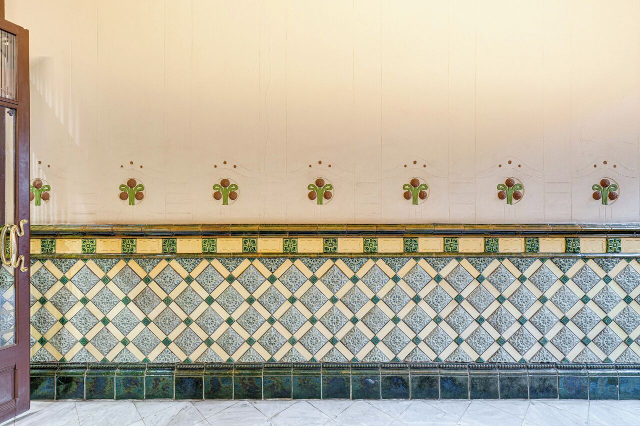 A tiled wall with a geometric pattern and a decorative border.