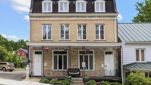 Ein zweistöckiges Reihenhaus mit Veranda, kleinem Garten und Briefkasten.