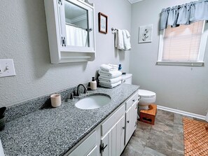 Een haardroger, handdoeken, zeep, toiletpapier