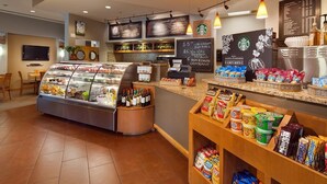 A bakery counter with a variety of baked goods and pastries, a coffee station with a menu board, and a seating area with a television. - Spacious 2BR Villa at Sheraton Lakeside Terrace Villas Near Beaver Creek Skiing (Avon)