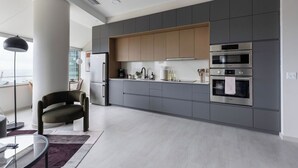 A modern kitchen with grey cabinets, stainless steel appliances, and a minimalist design.