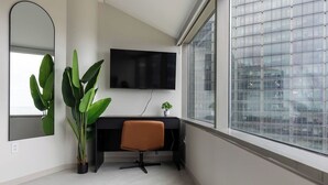 A modern office space with a desk, chair, and a large window.