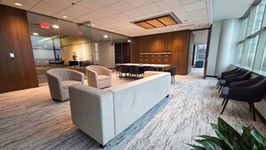 A modern lounge area with a sofa, chairs, and a small table.
