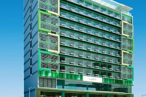 A multi-story hotel with a modern design, featuring balconies and a prominent entrance.
