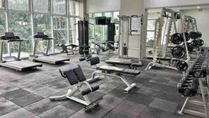 A gym with treadmills, weight machines, and free weights. - UPad Hotel (Manila)