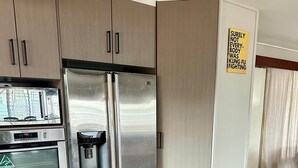 A kitchen with stainless steel appliances, including a refrigerator and an oven with a water dispenser. - That 70s House - 5 bedroom of comfort and history (Ayr)