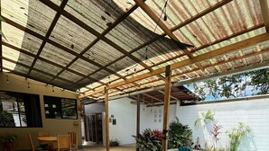 Un patio cubierto con piscina, mobiliario exterior y plantas en macetas.