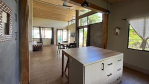 Una cocina amplia con una isla grande, pisos de madera y vistas al exterior.