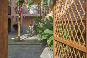 A courtyard with a wooden fence, a pathway, and a person walking a bicycle. - Express by M Village Nam Ky Khoi Nghia, a brand of Modern Village Lifestyle (Ho Chi Minh City)