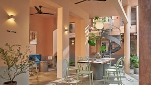 A modern lounge area with a spiral staircase, seating, and a ceiling fan. - Express by M Village Nam Ky Khoi Nghia, a brand of Modern Village Lifestyle (Ho Chi Minh City)