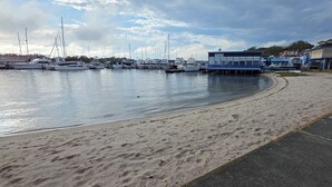 A marina with boats docked, a sandy beach, and a building labeled "The Port". - Skippers By The Bay - Lemon Tree Passage (Lemon Tree Passage)