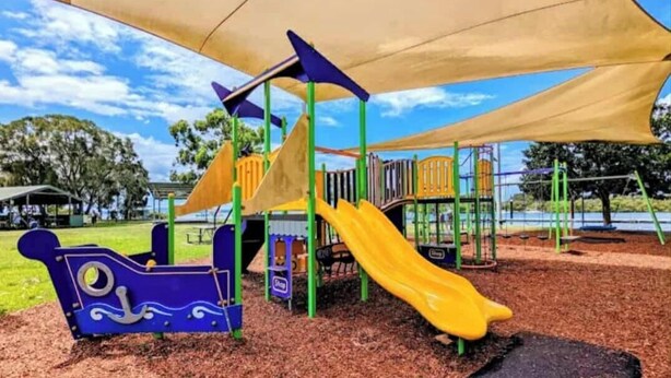 A playground with a slide, climbing structures, and a shaded area. - Skippers By The Bay - Lemon Tree Passage (Lemon Tree Passage)