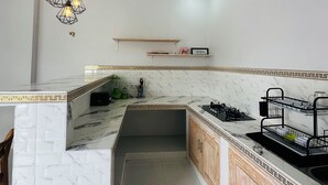 Une cuisine moderne dotée d’un plan de travail en marbre, de meubles en bois et d’un four encastré.