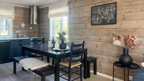 Een moderne keuken met houten wanden, een eethoek met een tafel en stoelen, en een keukeneiland.