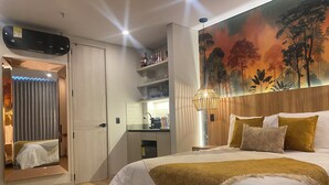 A hotel room with a bed, a desk, a mirror, and a wall with a nature-themed mural. - RYO 74B 7TH FLOOR VIP (Medellín)