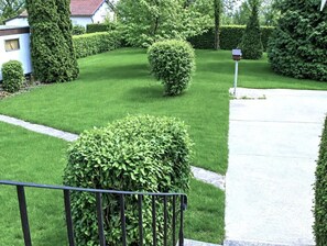 A well-maintained lawn with a neatly trimmed hedge, a mailbox, and a residential building in the background. - CHEZ MATHIEU - CHESTRES (CHESTRES)