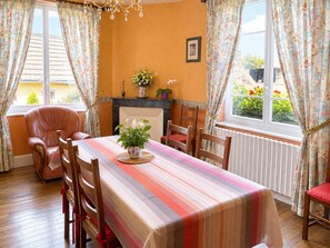 A dining room with a long table, chairs, a fireplace, and a view of the outside. - CHEZ MATHIEU - CHESTRES (CHESTRES)