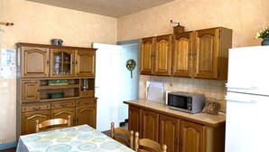 Cocina compacta con armarios de madera, un microondas y un refrigerador.