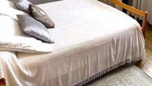 Un dormitorio con cama, almohadas, un espejo y una chimenea.