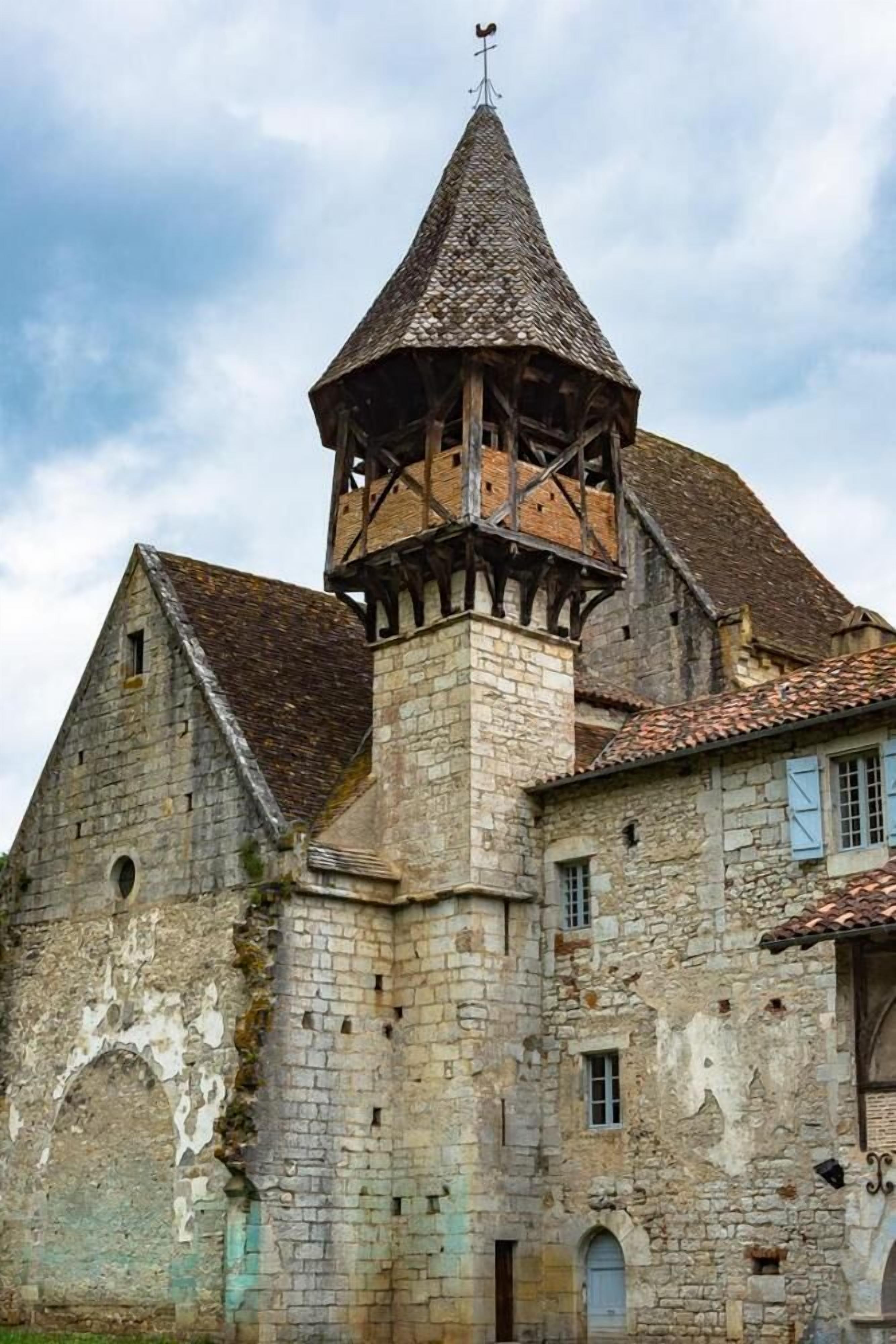 Ein historisches Steinhaus mit einem markanten Turm und einem Glockenturm.