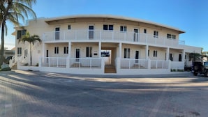 Un edificio a più piani con una facciata curva, balconi e un’area pavimentata.