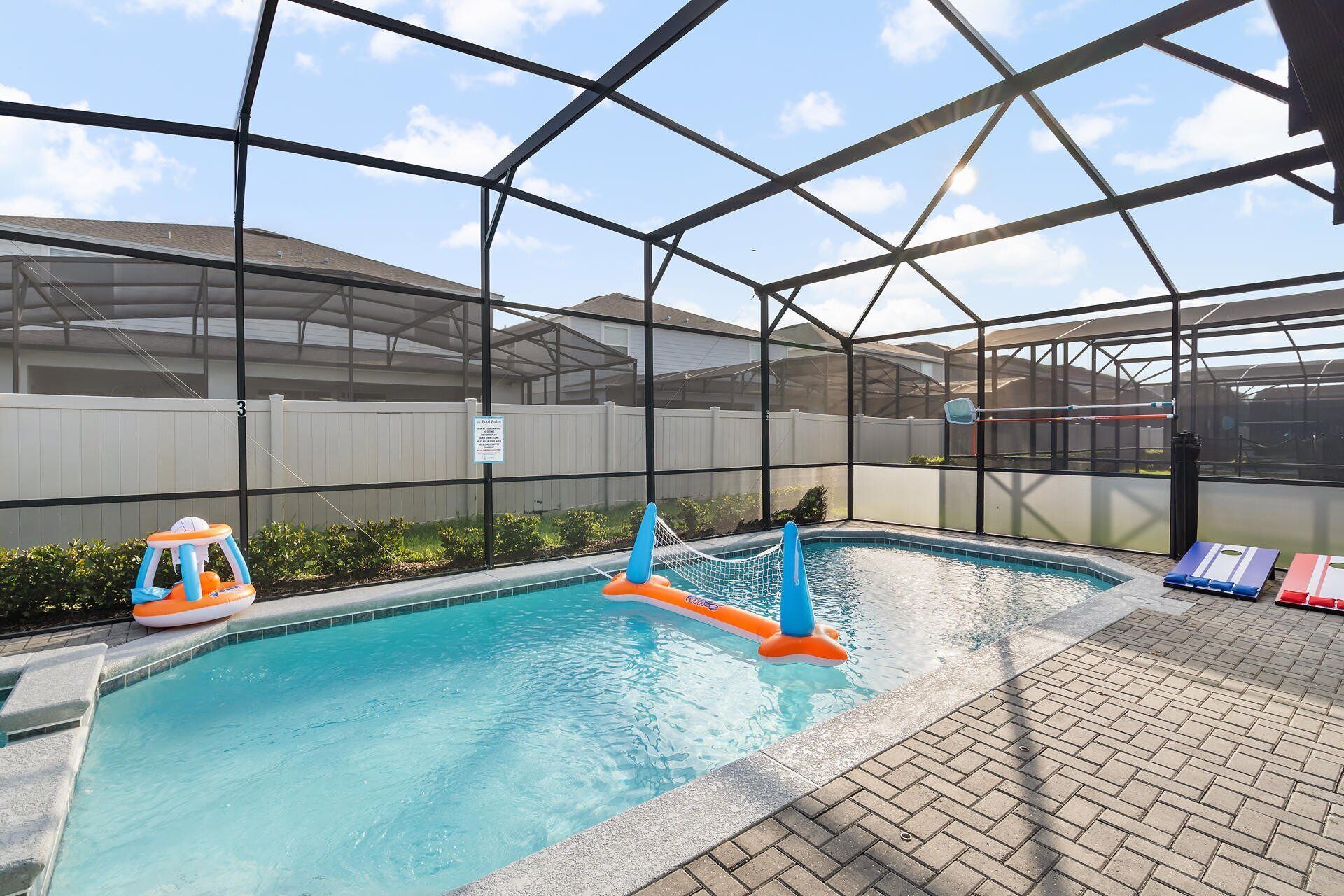 An indoor pool with clear blue water, surrounded by a metal frame structure.