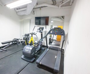 A gym with a treadmill, elliptical, and weight machines. - Beachside Retreat with Pool - Sleeps 4 (San Juan)