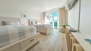 A modern bedroom with two beds, a desk, and a view of a balcony. - Beachside Retreat with Pool - Sleeps 4 (San Juan)