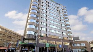 A multi-story hotel with a modern design, featuring a curved facade and numerous windows. - Holiday Inn Express TAOYUAN by IHG (Taoyuan)